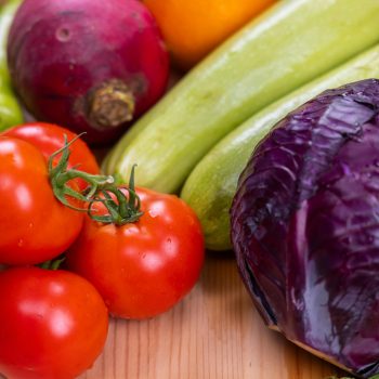 A vibrant assortment of fresh, organic vegetables on a wooden table, perfect for healthy eating.